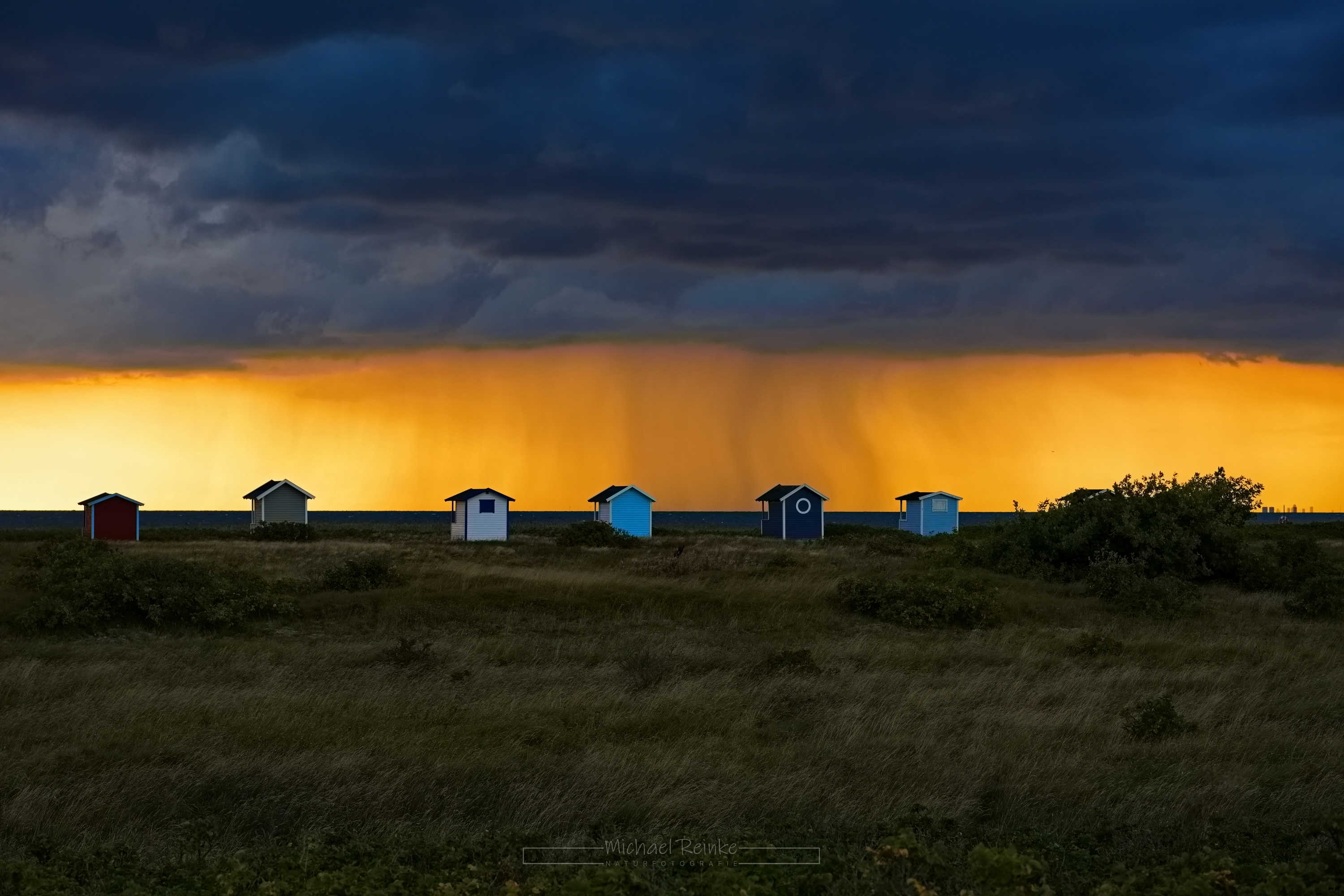 Badehütten vor einer Regenwand über dem Öresund