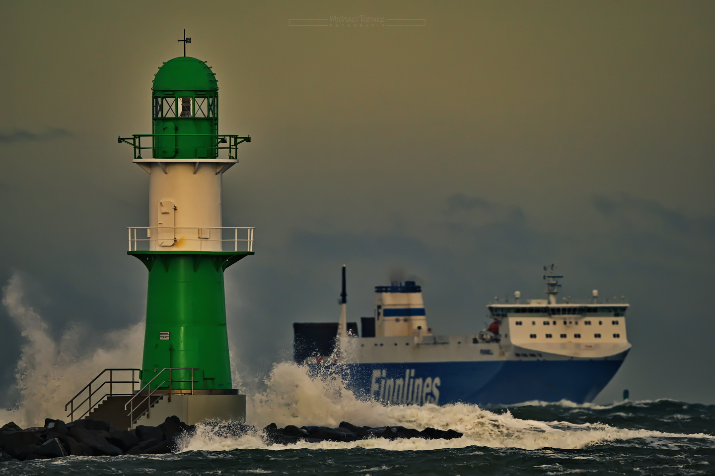 Ein Fährschiff passiert das Leuchtfeuer auf der Westmole